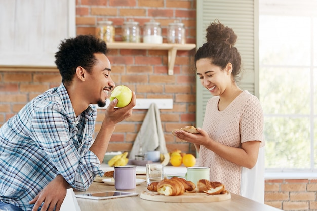 Une Femme Heureuse Fait Un Sandwich Parle Avec Son Mari Qui Est Assis En Face D Elle Mange Des Pommes Un Couple De Famille Passe Du Temps Libre Ensemble Photo Gratuite