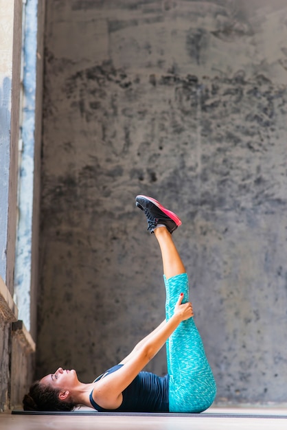 Femme Jambe étirement Exercice Sur Yoga Tapis Photo Gratuite