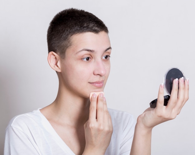Femme nettoyant en se regardant dans le miroir Photo gratuit