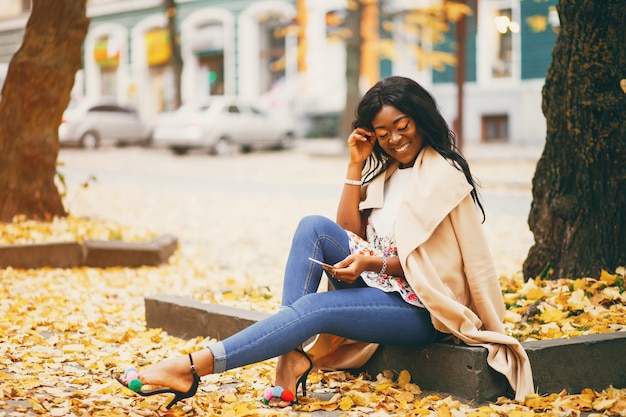 Femme Noire Assise Dans Une Ville D'automne  Photo Gratuite