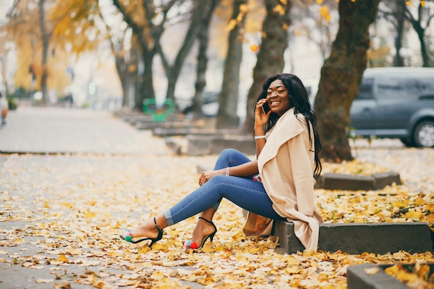 Femme Noire Assise Dans Une Ville D'automne  Photo Gratuite