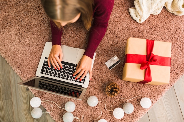 Femme, à, ordinateur portable, près, carte plastique, présent boîte, accroc, et, fairy lights Photo gratuit