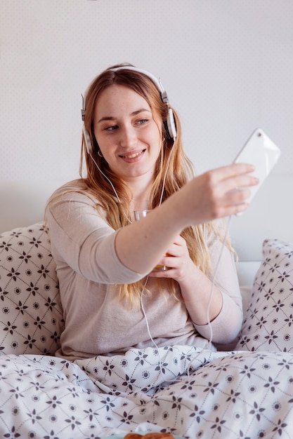 Femme Rousse Prenant Selfie Au Lit Photo Gratuite