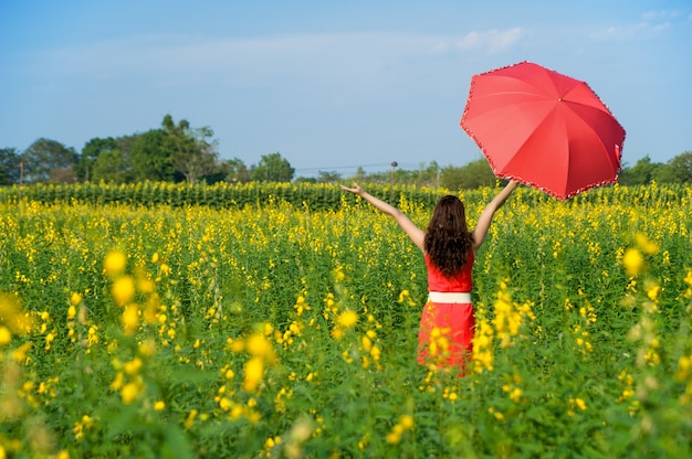 Femme Tenant Un Parapluie Rouge Dans Le Champ De La Fleur