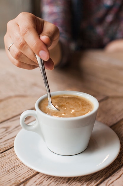 Femme, utilisation, cuillère, remuer, café, blanc, tasse, table Photo gratuit