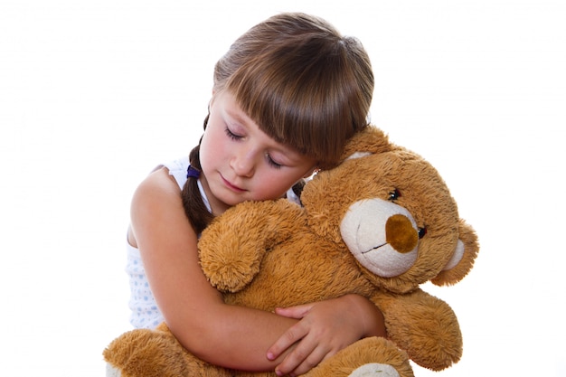 Fille adorable bambin étreignant un ours en peluche Photo Premium