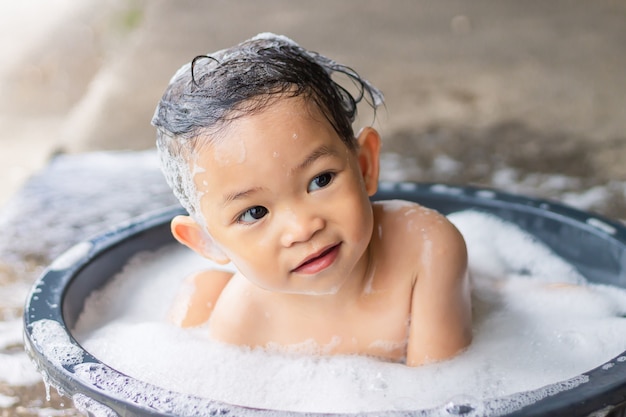 Fille Asiatique Bebe Heureux Prendre Un Bain Avec Des Bulles De Savon Et Jouer Un Jouet De Balle Elle Assise Dans Une Baignoire Photo Premium