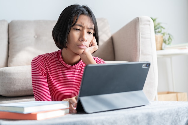 Fille Asiatique Est Assise En Pensant Et En Examinant Les Leons La