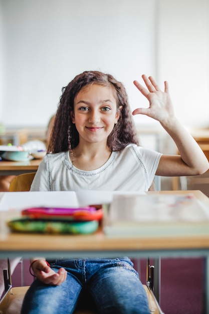 Fille Assise   La  Table  De L cole En Agitant La  Main 