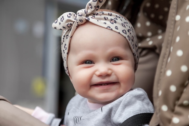 Une Fille Aux Yeux Bleus Souriante Et Emotive De Huit Mois S Assoit Dans Une Poussette