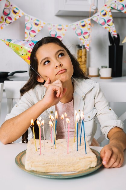 Fille Contemplee Avec Son Gateau D Anniversaire A La Maison Photo Gratuite