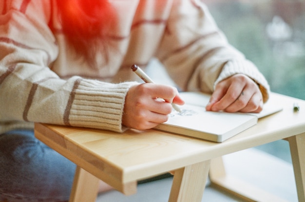 Fille écrit Dans Un Cahier Photo Gratuite