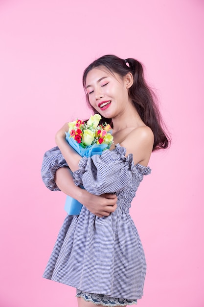 Fille fashion habiller avec des gestes de la main sur un fond rose. Photo gratuit