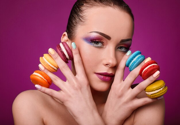 Fille de modèle de mode beauté glamour avec maquillage coloré et macarons. Photo Premium