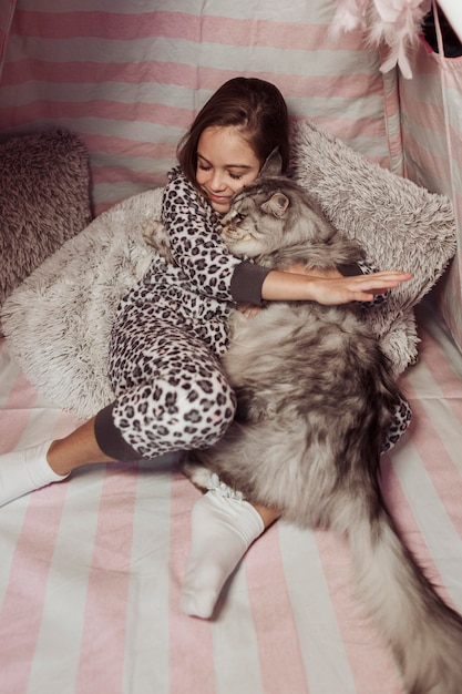 Fille En Pyjama Et Chat Etreignant Photo Gratuite