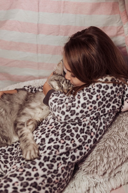 Fille En Pyjama Embrassant Son Chat Photo Gratuite