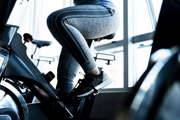 Fille de remise en forme à l'aide de vélo stationnaire Photo gratuit