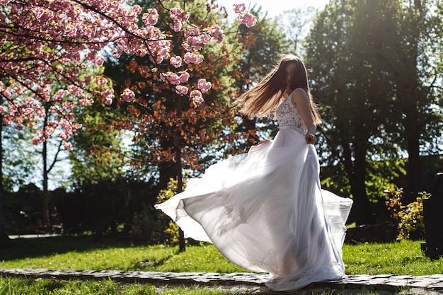 Fille En Robe Blanche Se Dresse Sous La Rose Fleur De Sakura