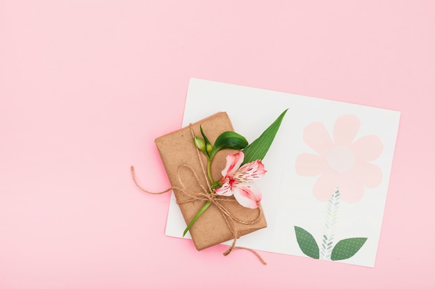 Fleur Rose Avec Une Boîte Cadeau Sur Une Table Rose