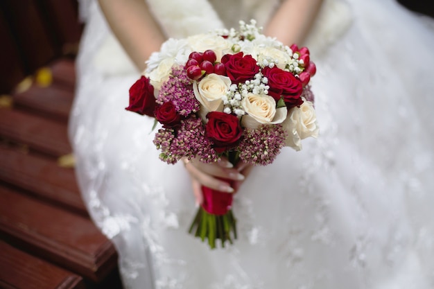 Fleurs De Mariage Bouquet De Mariee La Mariee Tenant Un Bouquet De Rouge Et Peche Roses Laitieres Et Fleurs Blanches Ceremonie De Mariage Photo Premium