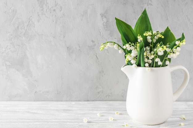 Fleurs De Muguet De Printemps Dans Un Vase Sur Fond De Beton Avec Copie Espace Nature Morte Photo Premium