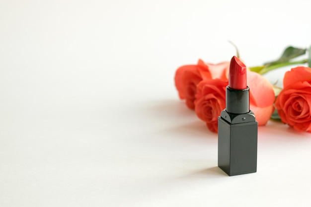 Fond blanc cosmétique beauté avec rouge à lèvres et roses Photo Premium