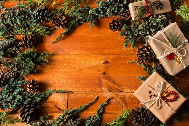 Fond en bois vue de dessus avec cadre de cônes de sapin de noël Photo gratuit