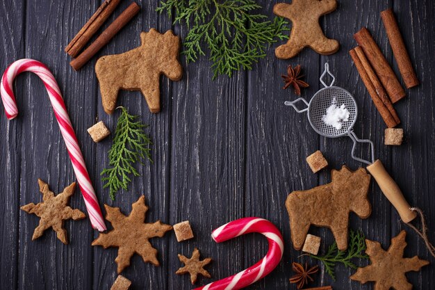 Fond de noël avec des biscuits, des arbres et de la cannelle. mise au point sélective, vue de dessus Photo Premium