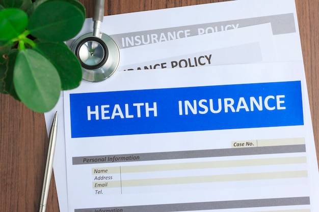 Formulaire d'assurance maladie avec stéthoscope en vue de dessus Photo Premium