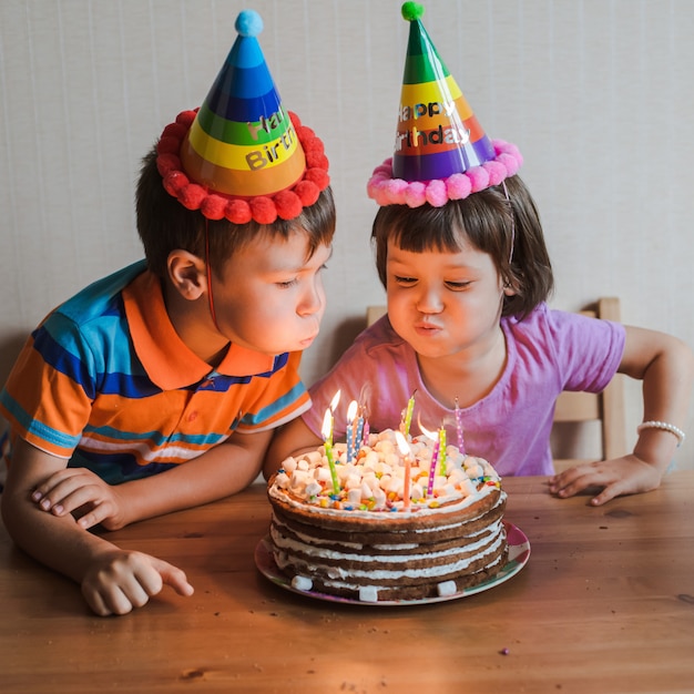 Frere Et Sœur Mangeant Un Gateau D Anniversaire Avec Des Bougies Qui Soufflent Et S Etreignent Photo Premium