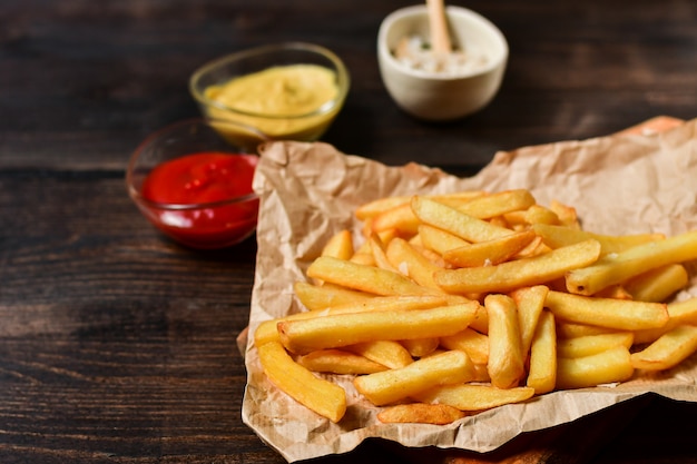 Frites avec du ketchup, de la moutarde et du sel. déjeuner de restauration rapide sur une table en bois. menu de déjeuner d'affaires, livraison de restauration rapide Photo Premium
