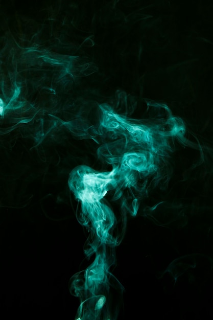 La fumée verte se déplace sur un fond noir et sombre Photo gratuit