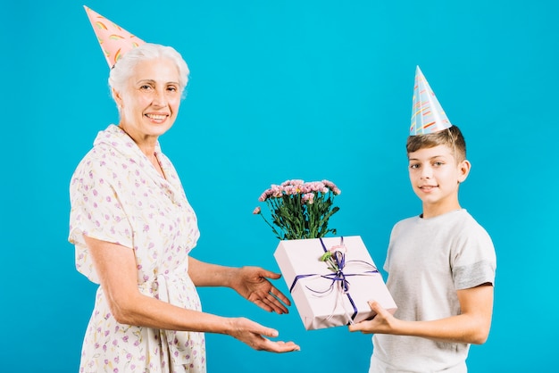 Garçon Donnant Un Cadeau Danniversaire Et Des Fleurs à Une