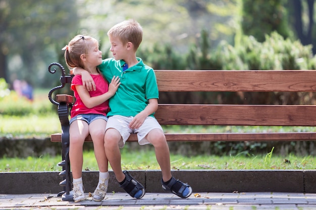 Garçon Et Fille Assis Sur Un Banc Dans Le Parc Photo Premium 