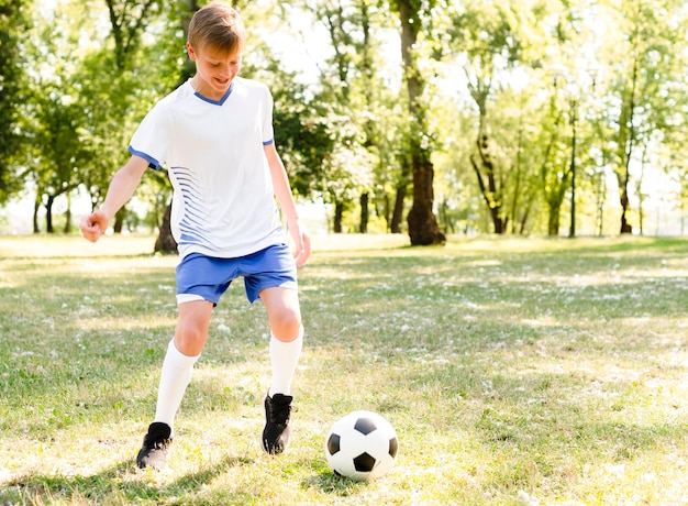 Garçon Jouant Au Football Seul Photo Gratuite