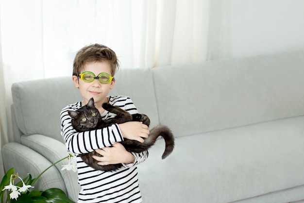 Garcon En Lunettes De Natation Est Titulaire D Un Chat Noir Et Reve De Nager En Ete Photo Premium