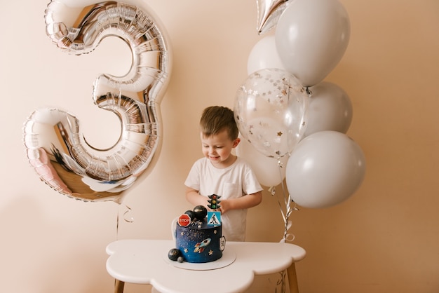 Garcon Mignon De 3 Ans Fete Son Anniversaire Et Mange Un Delicieux Beau Gateau Photo D Un Enfant Avec Des Ballons Photo Premium