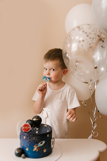 Garcon Mignon De 3 Ans Fete Son Anniversaire Et Mange Un Delicieux Beau Gateau Photo D Un Enfant Avec Des Ballons Photo Premium