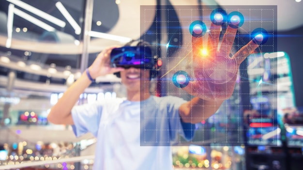 Un garçon utilisant un casque de réalité virtuelle, touchez l'interface virtuelle Photo Premium