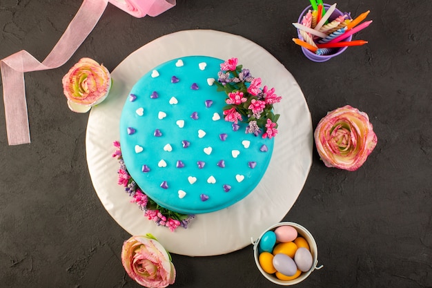 Un Gateau D Anniversaire Bleu Vue De Dessus Avec Des Fleurs Et Des Bonbons Tout Autour Photo Gratuite