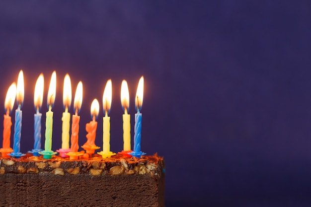 Gateau Brownie Joyeux Anniversaire Avec Des Arachides Du Caramel Sale Et Des Bougies Allumees Colorees Sur Le Fond Violet Copiez L Espace Pour Le Texte Photo Premium