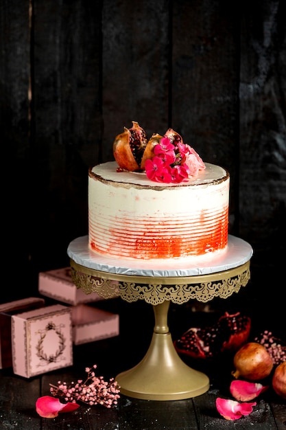 Gateau Cremeux En Blanc Avec Decoration Rouge Garni De Grenade Et De Fleurs Photo Gratuite