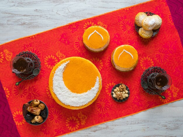 Gateau Dore Fait Maison Avec Un Croissant De Lune Servi Avec Une Tasse De The Et Des Dattes Mur Du Ramadan Photo Premium