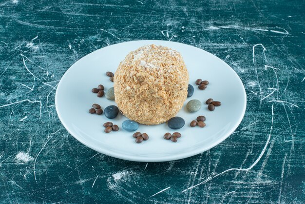 Gateau Ecureuil Sur Un Plateau Avec Des Bonbons Et Des Grains De Cafe Sur Fond Bleu Photo Gratuite