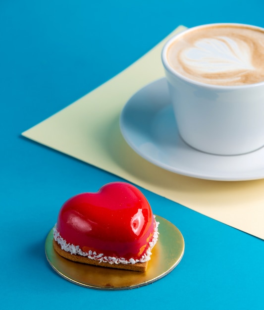 Gateau Gateau Mousse En Forme De Coeur Sur Bleu Avec Une Tasse De Cafe Photo Gratuite