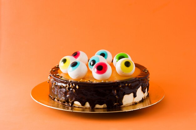 Gateau D Halloween Avec Decoration Yeux Bonbons Sur Fond Orange Photo Premium