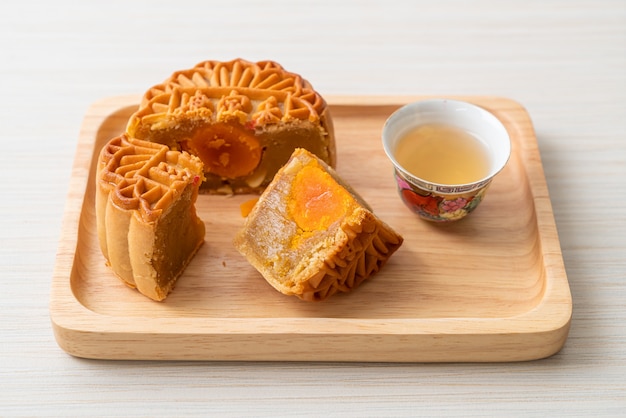 Gateau De Lune Chinois Au Durian Et Saveur De Jaune D Oeuf Avec Du The Sur Une Plaque De Bois Photo Premium