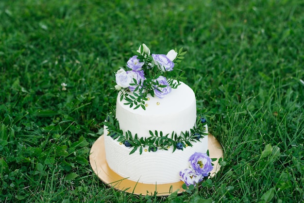 Gateau De Mariage Blanc Avec Des Fleurs Lilas Et Des Brins De Verdure Avec Des Fleurs Photo Premium