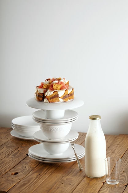 Gateau De Mariage Non Traditionnel Avec De La Creme Du Chocolat Et Du Pamplemousse En Equilibre Sur Une Pyramide De Tasses Et Soucoupes Blanches Avec Une Bouteille De Lait A Cote Photo Gratuite