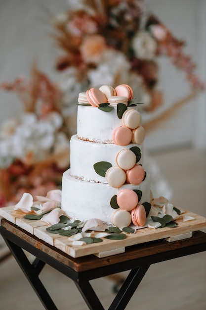 Gateau De Mariage A Trois Niveaux Sur Un Support Sur Le Fond De L Arche Photo Premium